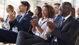 Smiling audience applauding at a business seminar